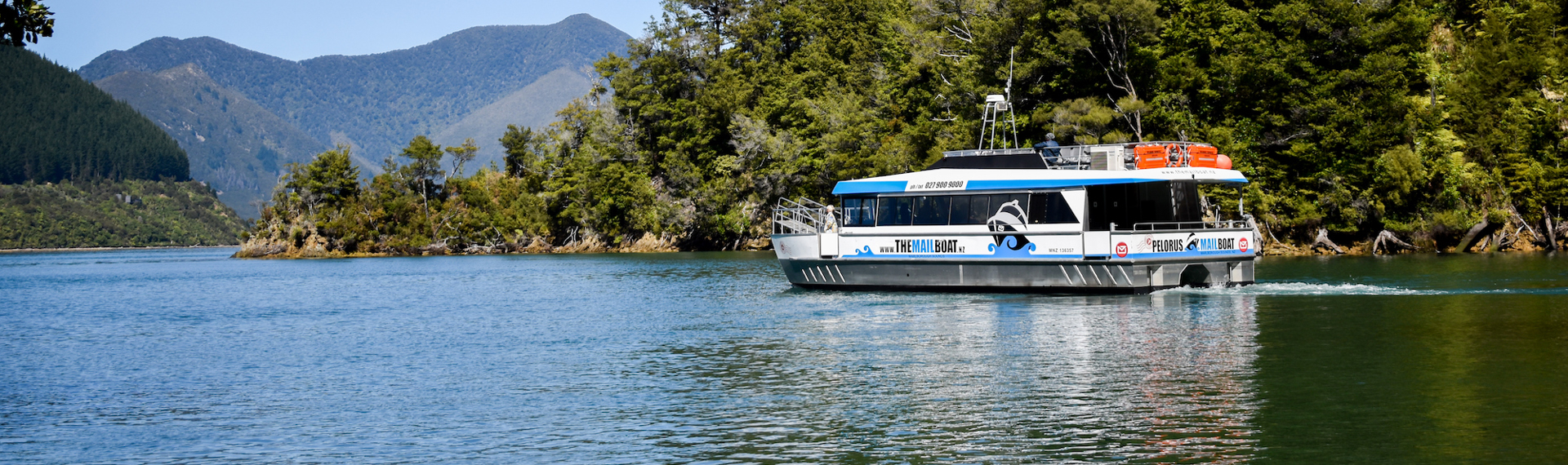 Pelorus Mail Boat cruising through a bush covered bay.